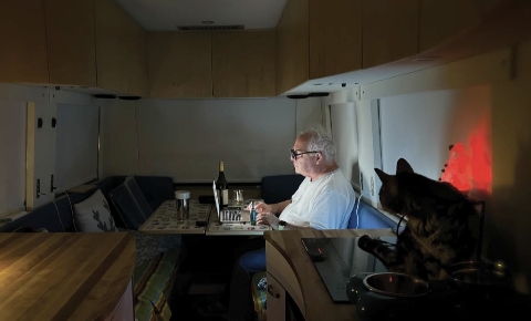 Luc Senay au travail dans l’intimité de son autocaravane. - Magazine Camper