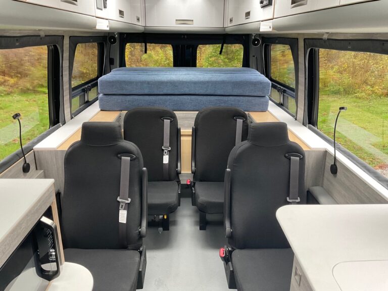 En plus de la lumière qui pénètre dans ce VR, on remarquera que le matelas situé à l’arrière est constitué de coussins reliés entre eux. Il suffit donc de les déplier lorsque l’on veut se coucher. Sur la photo, les deux sièges à l’arrière ne semble pas avoir d’appuie-têtes, or, il n’en est rien car, lorsque le matelas est déplié, un de ses coussins comprend deux cavités pour enrober les appuie-têtes. - Magazine Camper